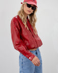 Red Vegan leather bomber jacket. Collar neckline. Snap button long sleeve closures. Front snap button down closures. Front pockets. Elastic hem. Fully lined. fall jacket. fall outfit
