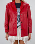 Vegan leather blazer. Single breast. Collar neckline. Front button down closure. Side pockets. Back slit. Fully lined. red leather blazer