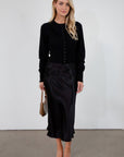 Black knit cardigan. Long sleeves. Front button down closure. Banded hems. Unlined. fall top. fall outfit. holiday outfit.