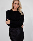Black knit cardigan. Long sleeves. Front button down closure. Banded hems. Unlined. fall top. fall outfit. holiday outfit.