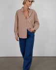 brown and white Striped woven shirt. Collar neckline. Long sleeves with button closures. Front button down closures. Unlined. oversized button down top