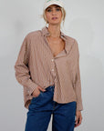 brown and white Striped woven shirt. Collar neckline. Long sleeves with button closures. Front button down closures. Unlined. oversized button down top
