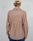 brown and white Striped woven shirt. Collar neckline. Long sleeves with button closures. Front button down closures. Unlined. oversized button down top