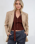 Ribbed knit sleeveless top. V-neckline. Front button down closure. Unlined. Neck tie. brown vest top. top with scarf. fall top.