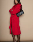 Vegan leather bag. Fixed top strap. Front twist latch closure. Fully lined. Inner pockets. 