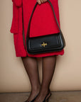 Vegan leather bag. Fixed top strap. Front twist latch closure. Fully lined. Inner pockets. 