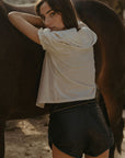 Woven top. Collar neckline. Short sleeves with elastic sleeve openings. Front tie closure. Unlined. coquette cream top