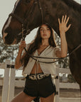Woven top. Collar neckline. Short sleeves with elastic sleeve openings. Front tie closure. Unlined. coquette cream top