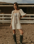 Floral printed woven dress. Elastic neckline. front tie closure. 3/4 sleeves with elastic openings. Unlined. floral mini dress. rumored mini dress. spring mini dress