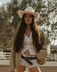 Denim jacket. Collar neckline. Long sleeves. Front zipper closure. Front pockets. Elastic sides. Fully lined. barn jacket. beige barn jacket. ranch shoot