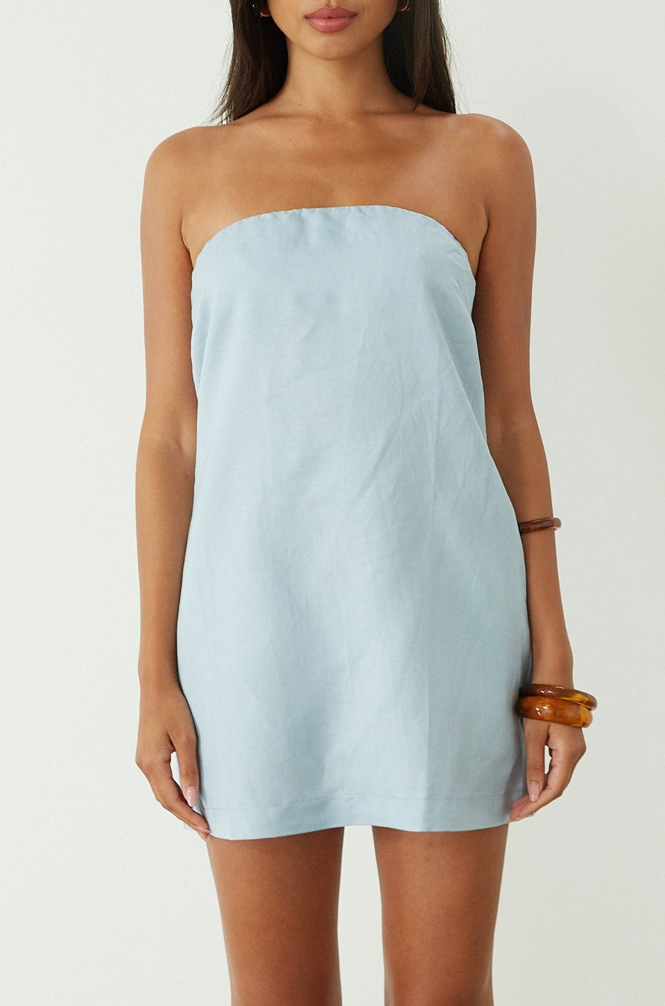 Woven dress. Inner rubber grip lining. Side pockets. Elastic back strap. Back cut out. Partially lined. Blue mini dress. blue strapless mini dress. guest wedding dress. summer dress. summer outfit.