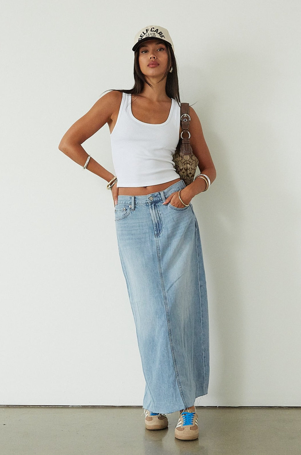 Denim maxi skirt. Button and zipper fly. Five pocket construction. Back slit. Raw hem. Unlined. blue denim maxi skirt. denim maxi skirt with back slit. summer outfit. casual outfit. cute casual outfit. 