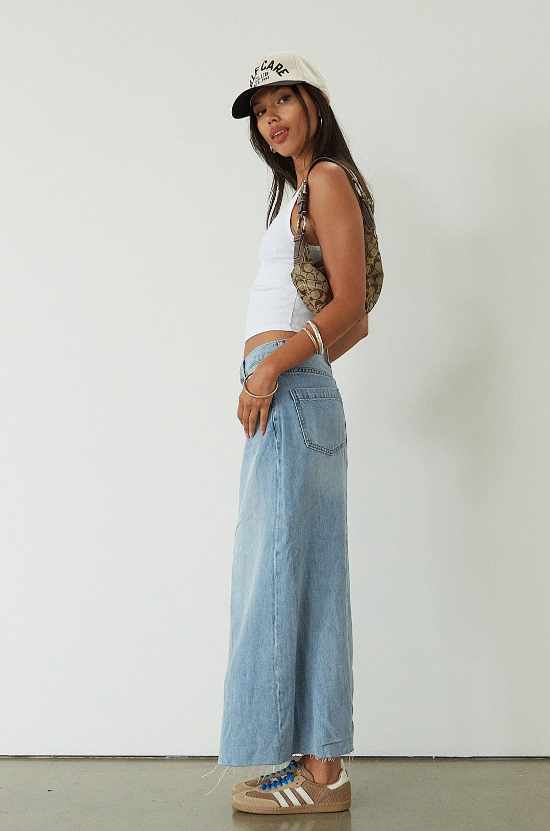 Denim maxi skirt. Button and zipper fly. Five pocket construction. Back slit. Raw hem. Unlined. blue denim maxi skirt. denim maxi skirt with back slit. summer outfit. casual outfit. cute casual outfit. 
