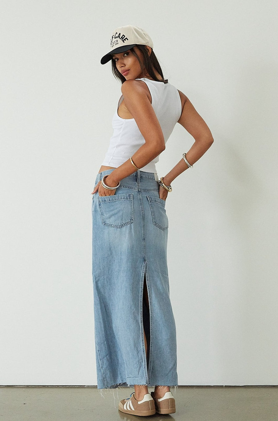 Denim maxi skirt. Button and zipper fly. Five pocket construction. Back slit. Raw hem. Unlined. blue denim maxi skirt. denim maxi skirt with back slit. summer outfit. casual outfit. cute casual outfit. 
