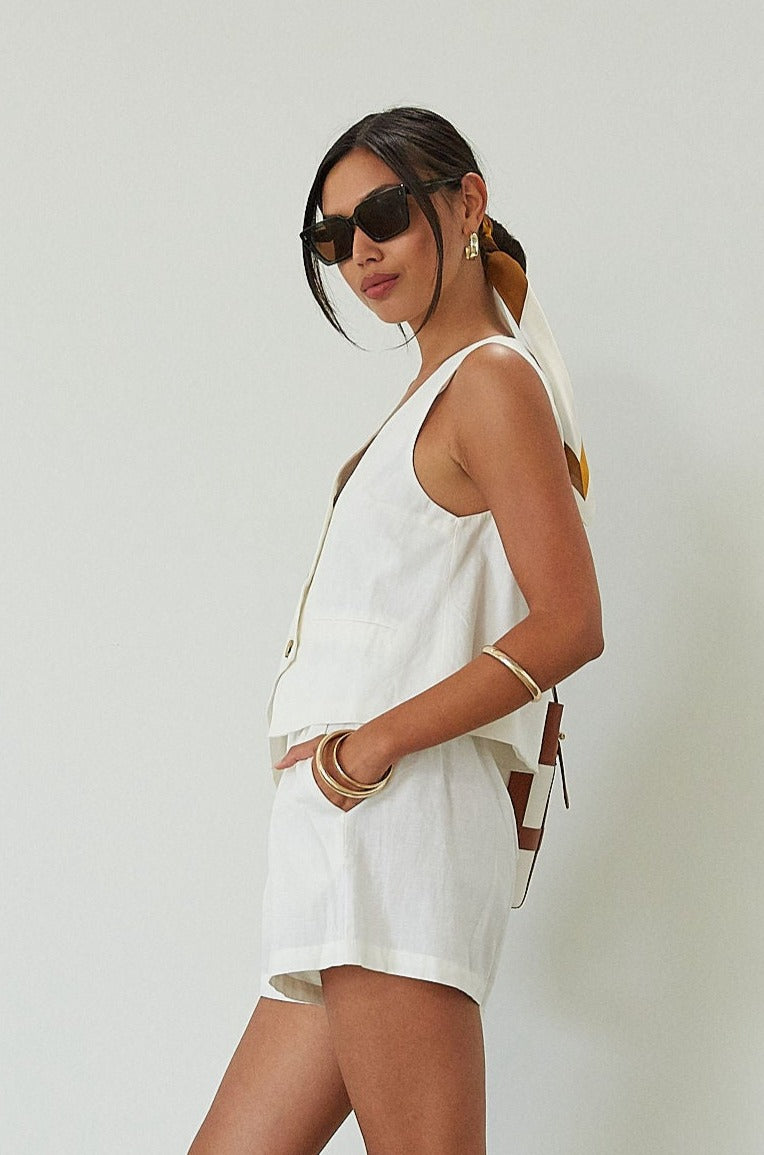 Woven cropped vest. Front button down closures. Faux front pockets. Fully lined. Woven shorts. Elastic waistband. Side pockets. Unlined. summer set outfit. summer outfit. vest and short set. white set.