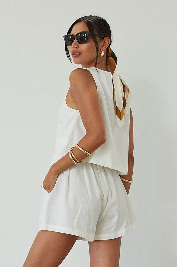 Woven cropped vest. Front button down closures. Faux front pockets. Fully lined. Woven shorts. Elastic waistband. Side pockets. Unlined. summer set outfit. summer outfit. vest and short set. white set.