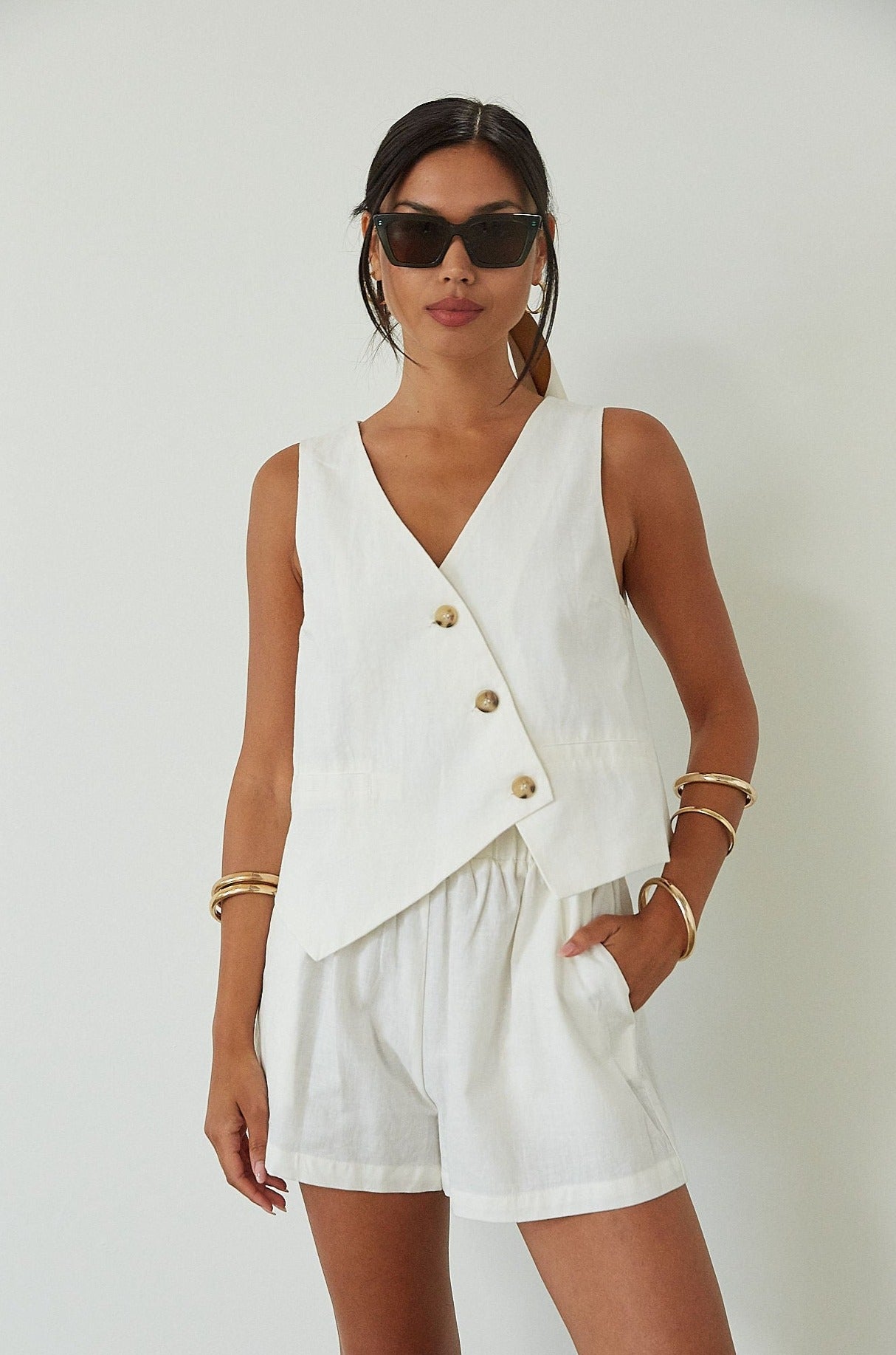 Woven cropped vest. Front button down closures. Faux front pockets. Fully lined. Woven shorts. Elastic waistband. Side pockets. Unlined. summer set outfit. summer outfit. vest and short set. white set.