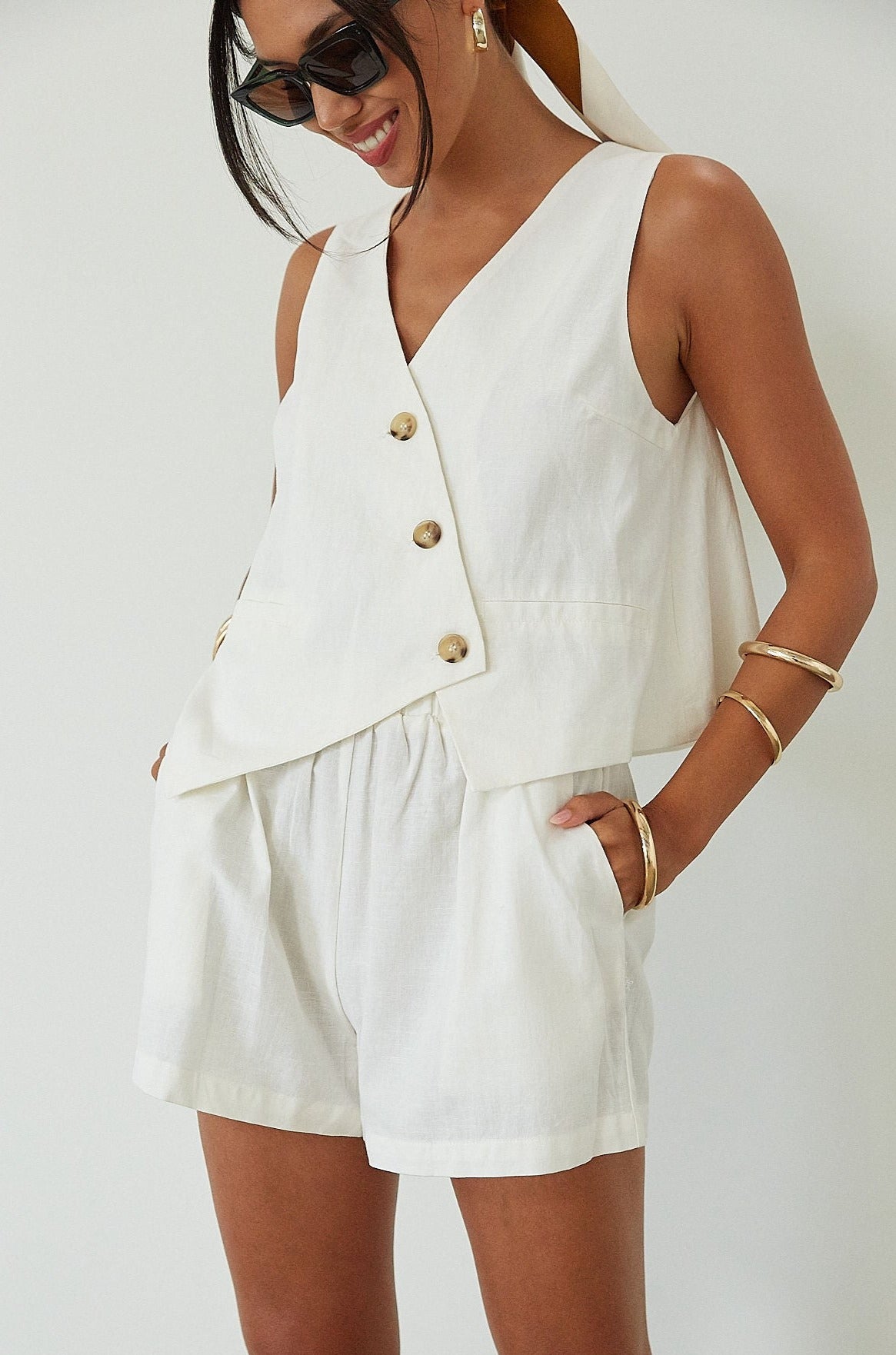 Woven cropped vest. Front button down closures. Faux front pockets. Fully lined. Woven shorts. Elastic waistband. Side pockets. Unlined. summer set outfit. summer outfit. vest and short set. white set.