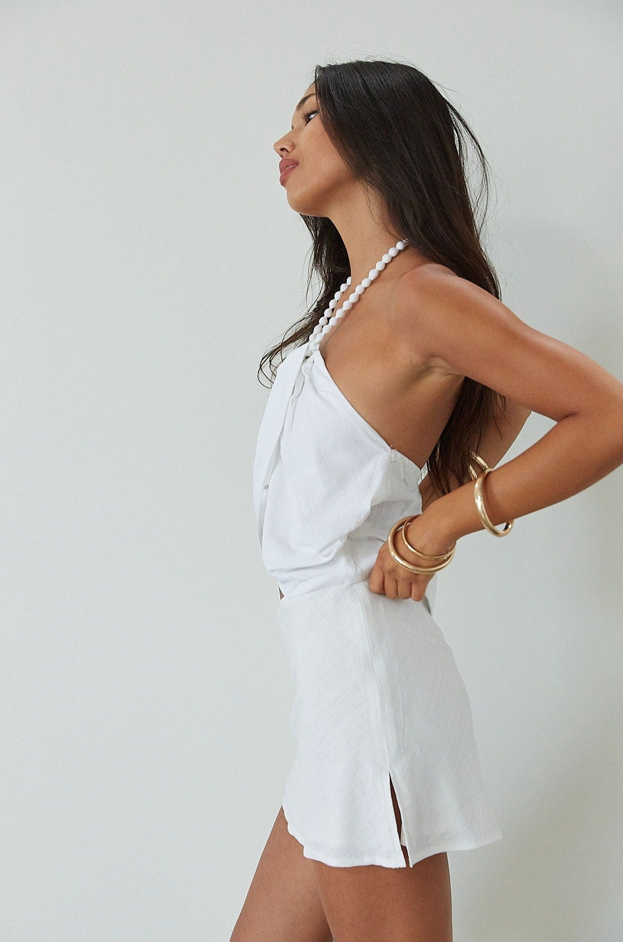 Woven crop top. Beaded halter neckline with adjustable tie closure. Front snap closure. Unlined. white cropped tank top. white halter top. asymmetrical top. summer top. vacation top. vacation outfit