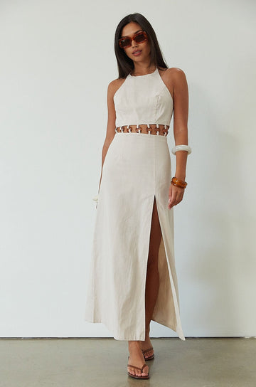 Woven maxi dress. Adjustable halter tie neckline. Back hook and eye and zipper closures. Ring waist details. Front slit. Fully lined. tan maxi dress. beige maxi dress. summer vacation dress. 