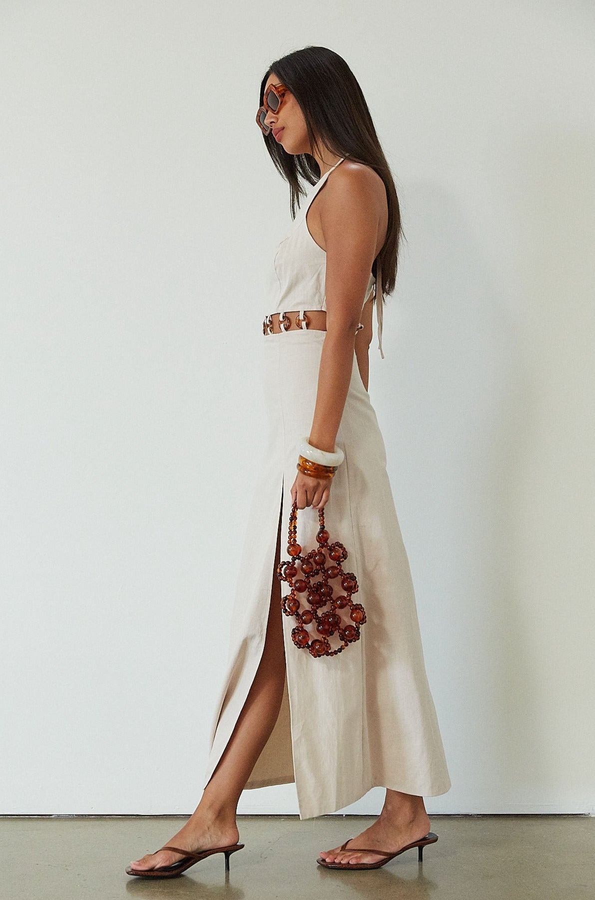 Woven maxi dress. Adjustable halter tie neckline. Back hook and eye and zipper closures. Ring waist details. Front slit. Fully lined. tan maxi dress. beige maxi dress. summer vacation dress. 