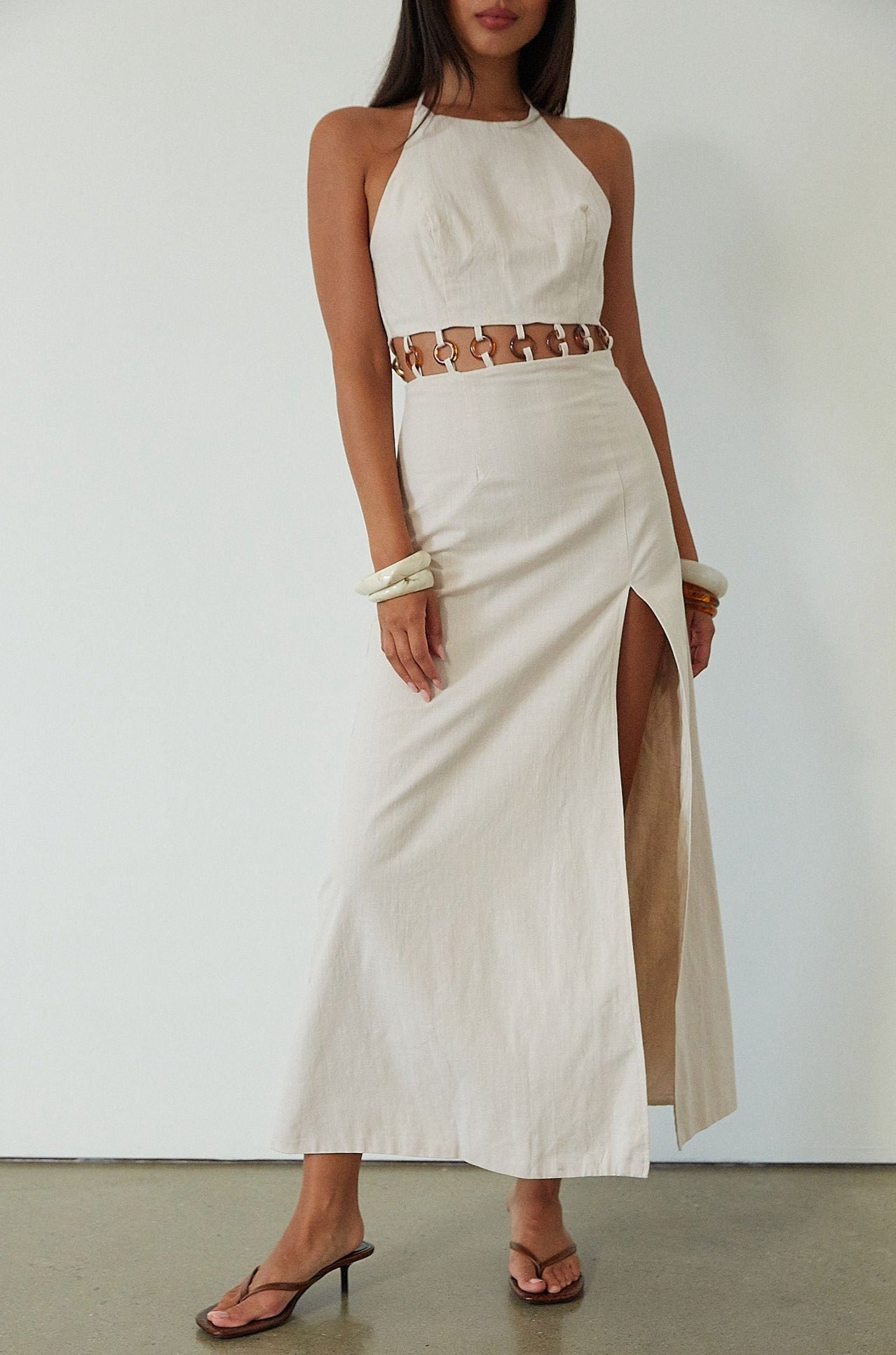 Woven maxi dress. Adjustable halter tie neckline. Back hook and eye and zipper closures. Ring waist details. Front slit. Fully lined. tan maxi dress. beige maxi dress. summer vacation dress. 