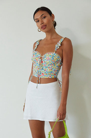 Floral printed woven crop top. Ruffle adjustable tie straps. Underwire cups. Front tie. Adjustable drawstring sides. Ruched bodice. Boning in bodice. Back hook and eye and exposed zipper closure. Fully lined. floral tank top. floral cropped tank. summer top. spring top