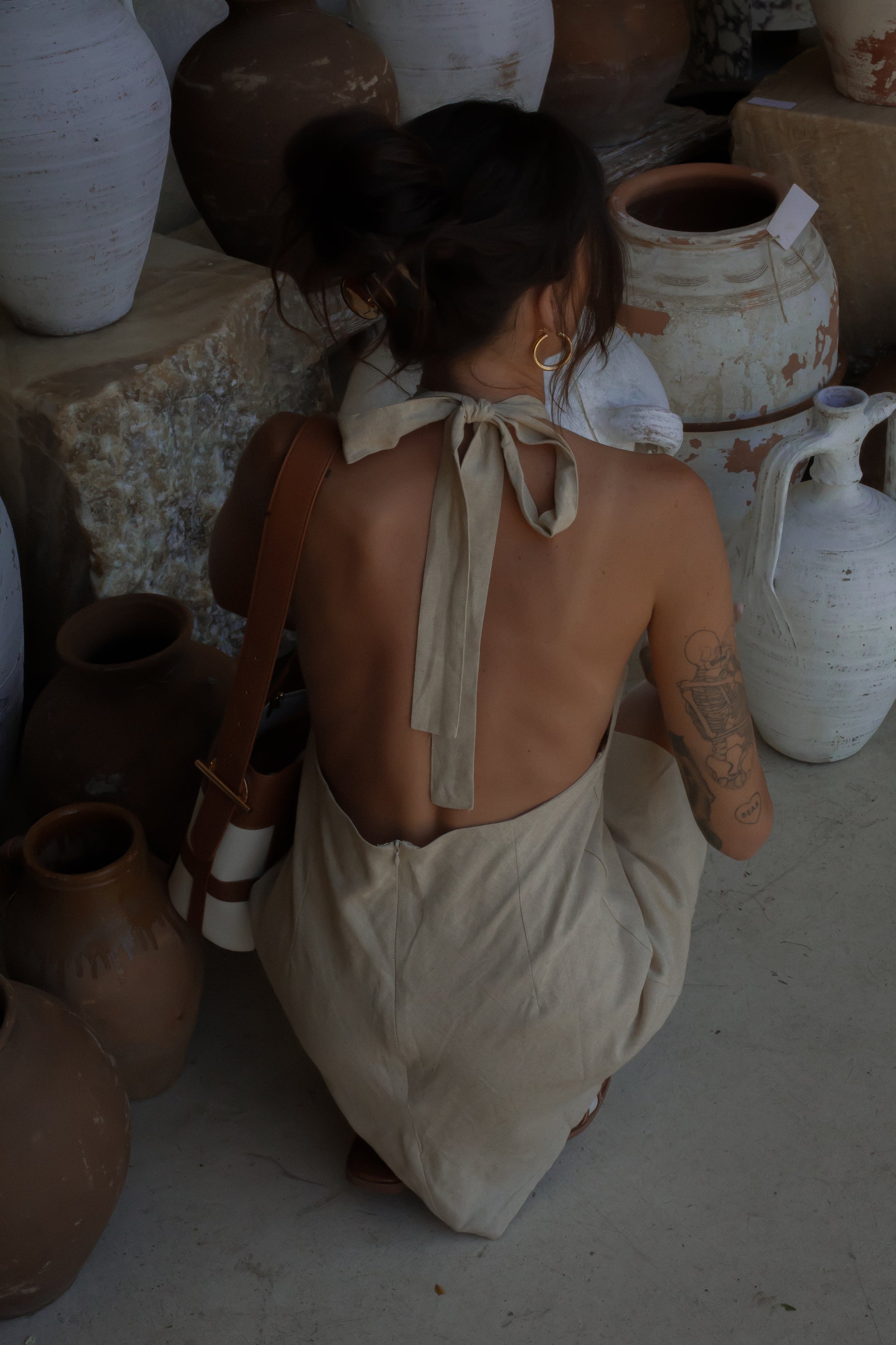 Woven dress. Adjustable halter neckline with tie closure. Back hook and eye and zipper closures. Fully lined. European summer. European summer dress. European summer aesthetic. Tuscany outfit inso. Tuscany aesthetic. Summer dress. oat mini dress. beige mini dress. tan mini dress. mini halter neck dress. summer outfit. everyday dress. vacation dress. outfit to wear to tuscany. nice dinner dress. dinner dress. day dress. 