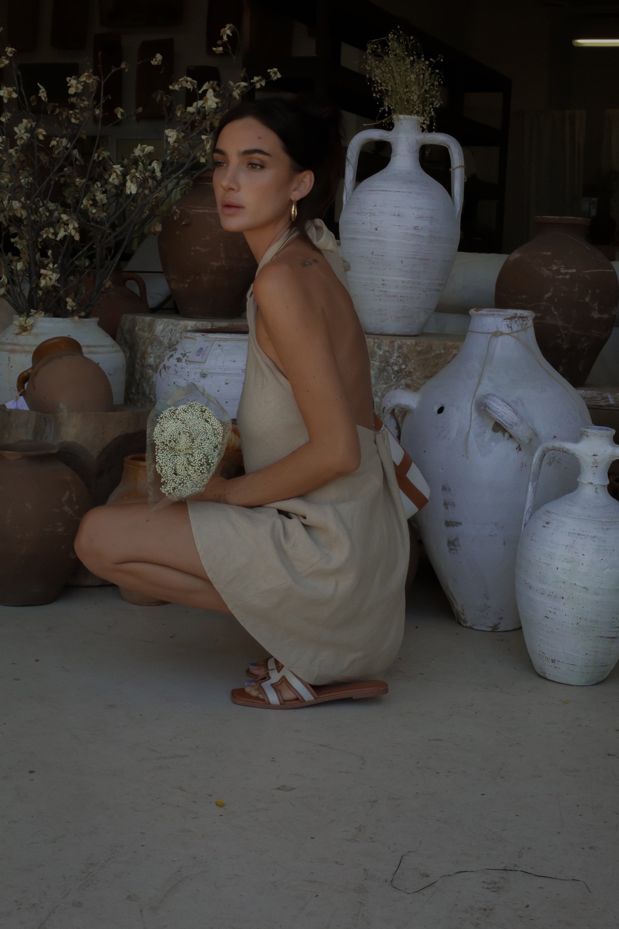 Woven dress. Adjustable halter neckline with tie closure. Back hook and eye and zipper closures. Fully lined. European summer. European summer dress. European summer aesthetic. Tuscany outfit inso. Tuscany aesthetic. Summer dress. oat mini dress. beige mini dress. tan mini dress. mini halter neck dress. summer outfit. everyday dress. vacation dress. outfit to wear to tuscany. nice dinner dress. dinner dress. day dress. 