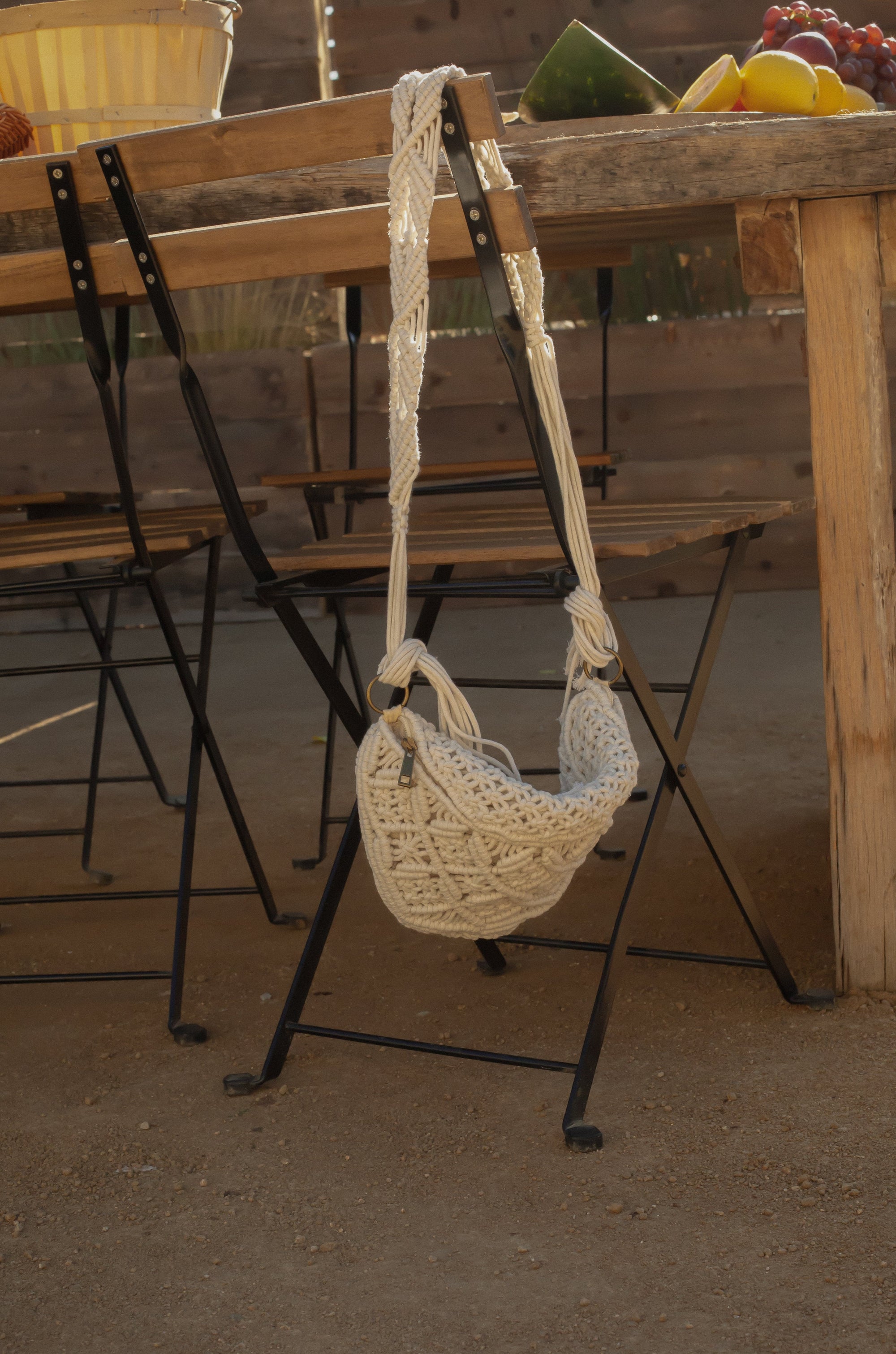 Woven macrame crossbody bag. Fixed strap. Fringe trim. Front zipper closure. Fully lined.