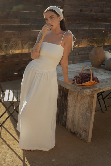 Sleeveless maxi dress. Elastic smocked bodice. Gauze skirt. Adjustable toe straps. Side pockets. Partially lined. European summer aesthetic. Tuscany outfit inso. Tuscany aesthetic. Summer dress. white maxi dress. summer outfit. everyday dress. vacation dress. outfit to wear to tuscany. day dress. white ruffled maxi dress. shoulder tie strap dress