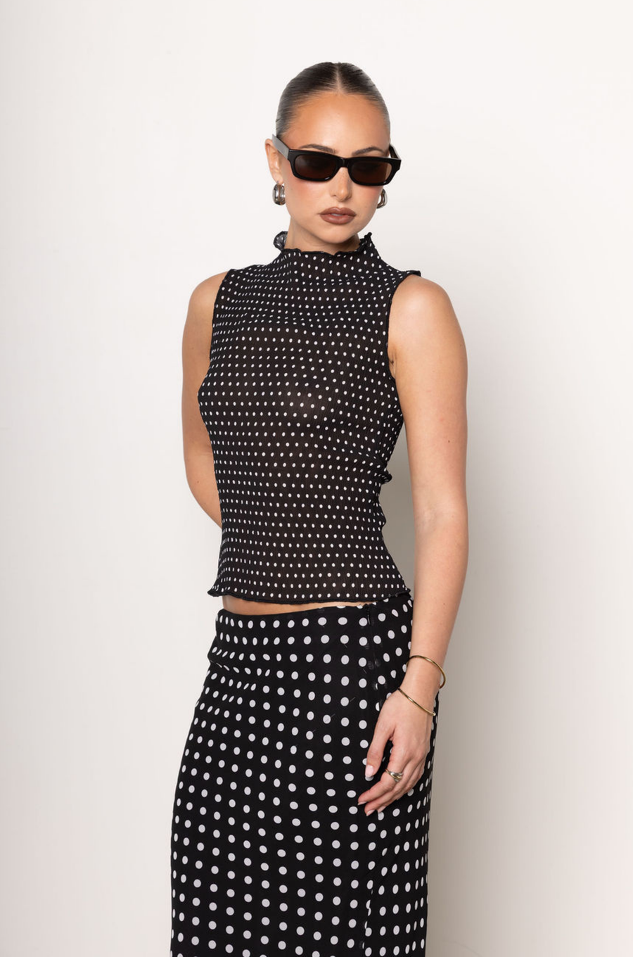 Polka dot chiffon tank top
High neck line
Sleeveless
Unlined/Sheer
black and white sheer polka dot tank top
going out top