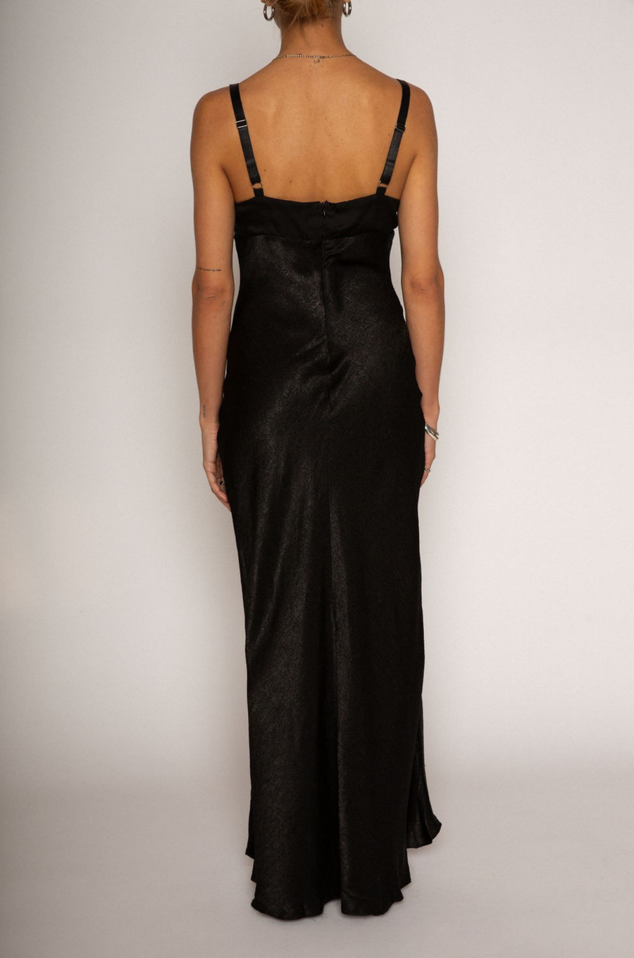 Textured black satin maxi dress. Adjustable elastic straps. Back hook and eye and zipper closures. Partially lined. black wedding guest dress