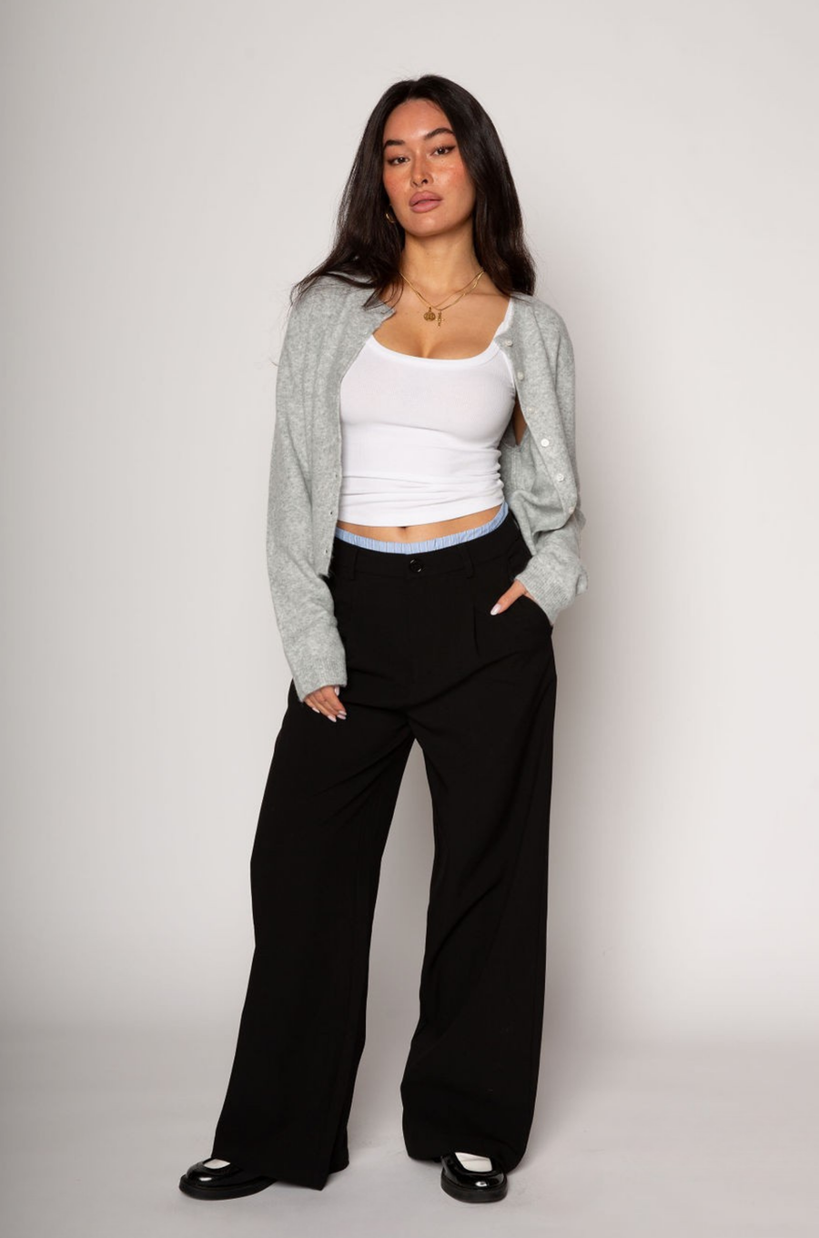 Black stretch trouser pants. Trimmed waist. Button and zipper fly. Side pockets. Faux back pockets. Unlined. layered slacks