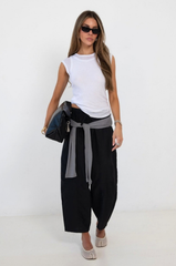 black Windbreaker material track pant
Mid rise
Ankle length
4 pocket construction
Adjustable elastic drawstring