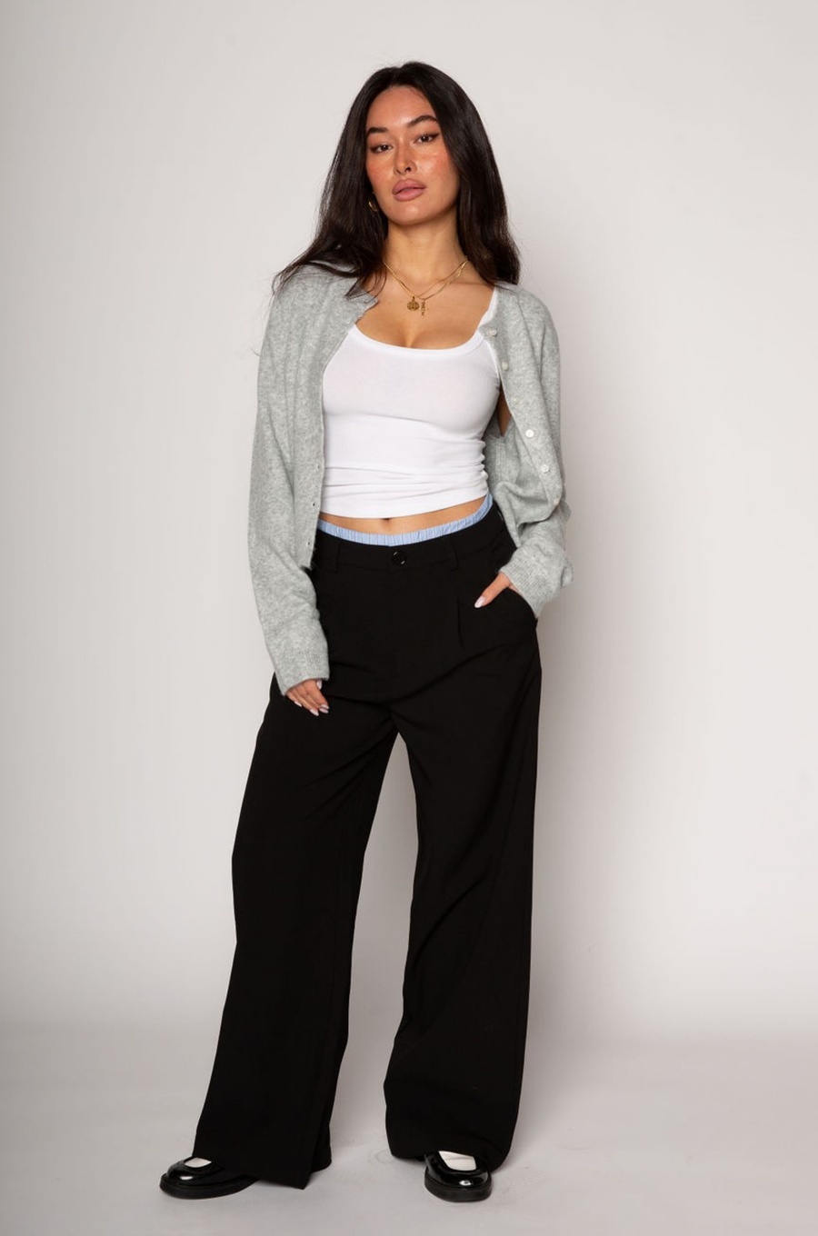 Black stretch trouser pants. Trimmed waist. Button and zipper fly. Side pockets. Faux back pockets. Unlined. layered slacks