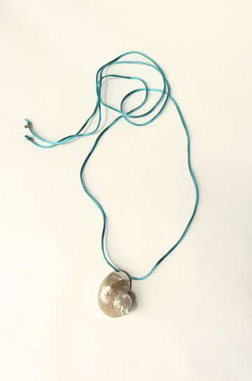 Turbo shell silk cord necklace
Polished and hand-drilled
Silk cord with gold plated beads
Can be worn multiple ways
Length: 26"
Turbo shell approx. 1.5"
Size color and shape of shell may vary slightly