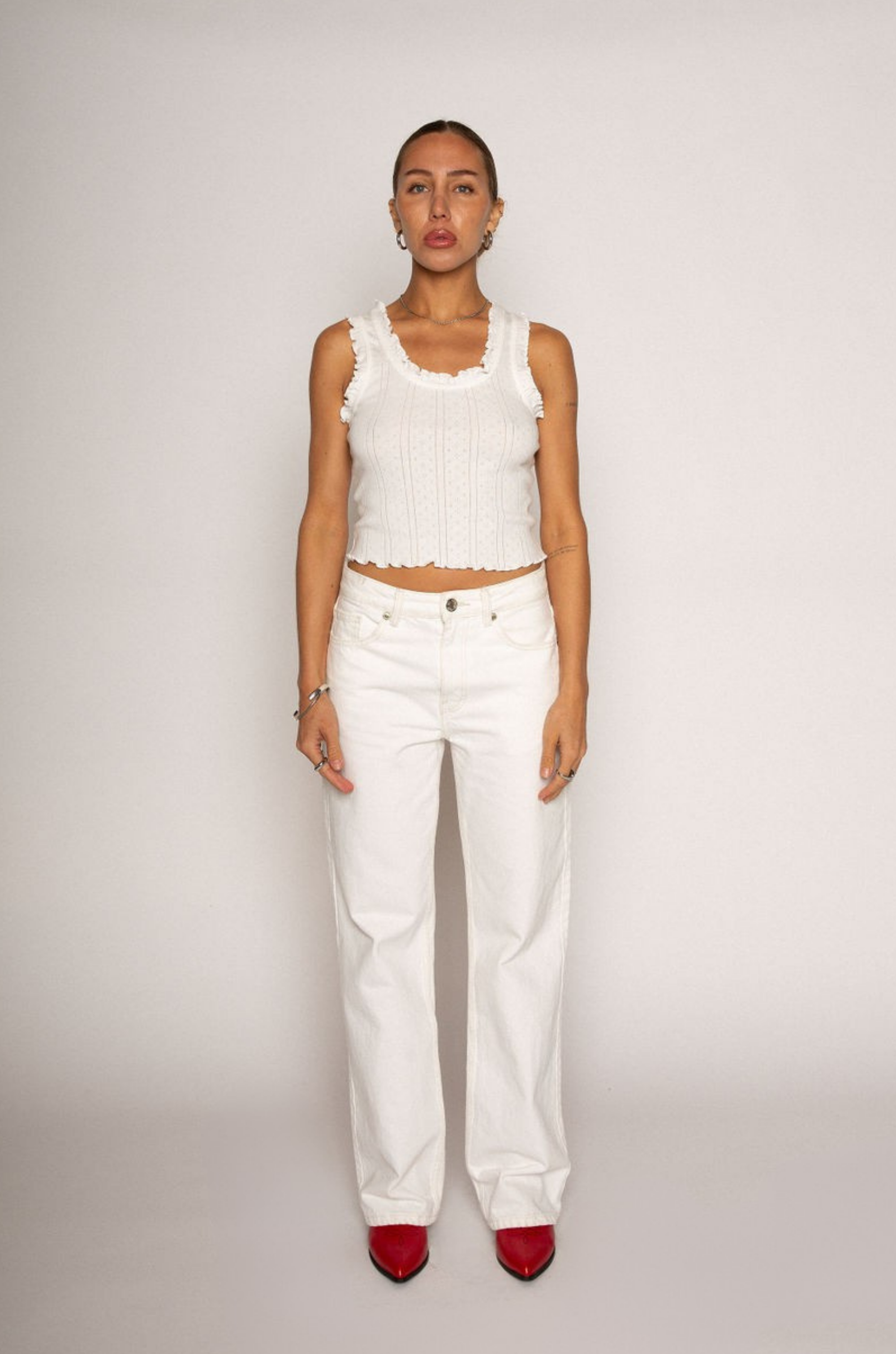 Eyelet pointelle tank top
Ruffle trim detail
Racerback
Scoop neckline
Has stretch
Unlined/partial sheer
White basic tank top