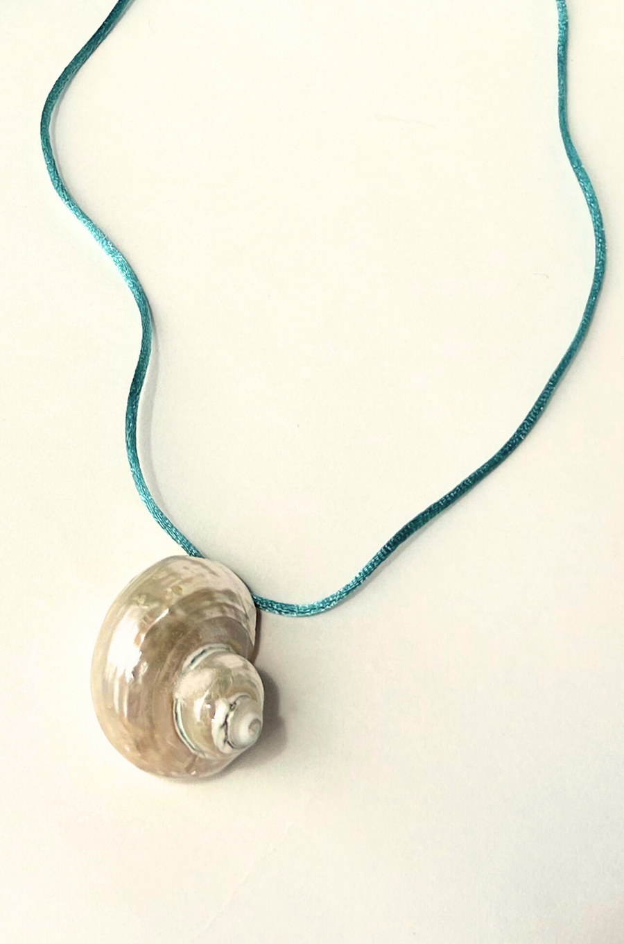 Turbo shell silk cord necklace
Polished and hand-drilled
Silk cord with gold plated beads
Can be worn multiple ways
Length: 26"
Turbo shell approx. 1.5"
Size color and shape of shell may vary slightly