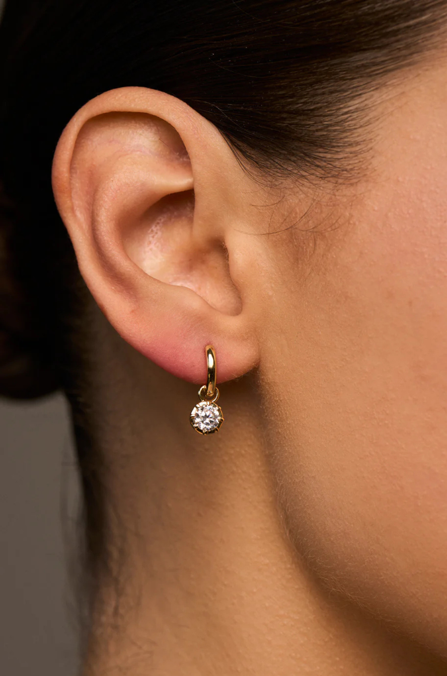 A modern bezel set charm hoop that pairs clean design with luminous sparkle
Available in 14kt gold plated brass or Rhodium plated brass
Stones are white cz and measure 5.0mm each
Huggie measures 8mm inner diameter.
Snap Hinge Closure
Sold as a pair
gold cz hoop earring