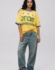 Game on. Keep your eye on the ball in this OS Ringer Tee designed in colors inspired by the Team Brasil jersey. Featuring an athletic influence with rib contrast along the neckline and arms.
Oversized fit and length, accented with dropped shoulders
Available in just one size
Length: 27.5"
Cotton
yellow brazil brasil world cup jersey tee