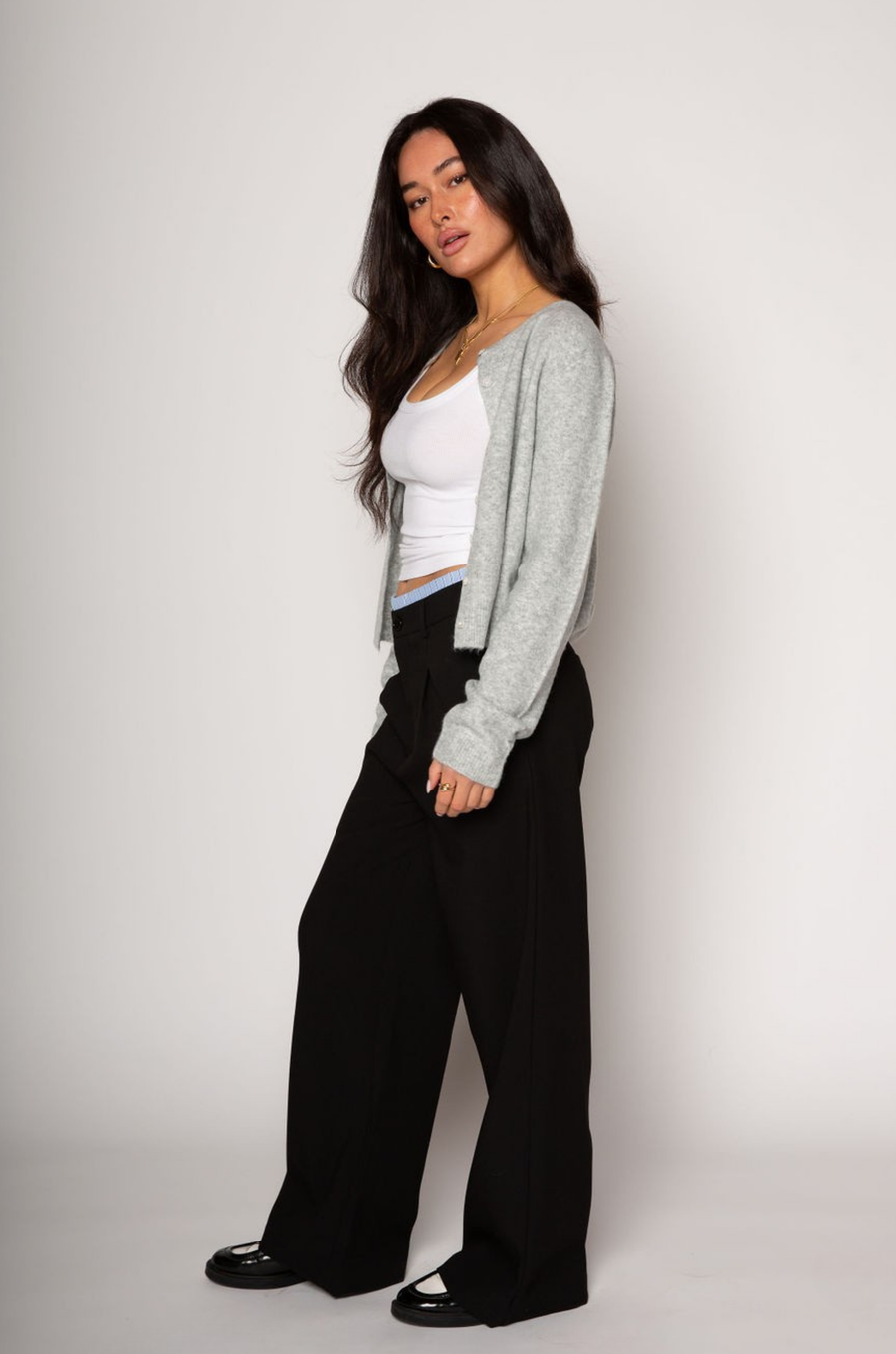 Black stretch trouser pants. Trimmed waist. Button and zipper fly. Side pockets. Faux back pockets. Unlined. layered slacks