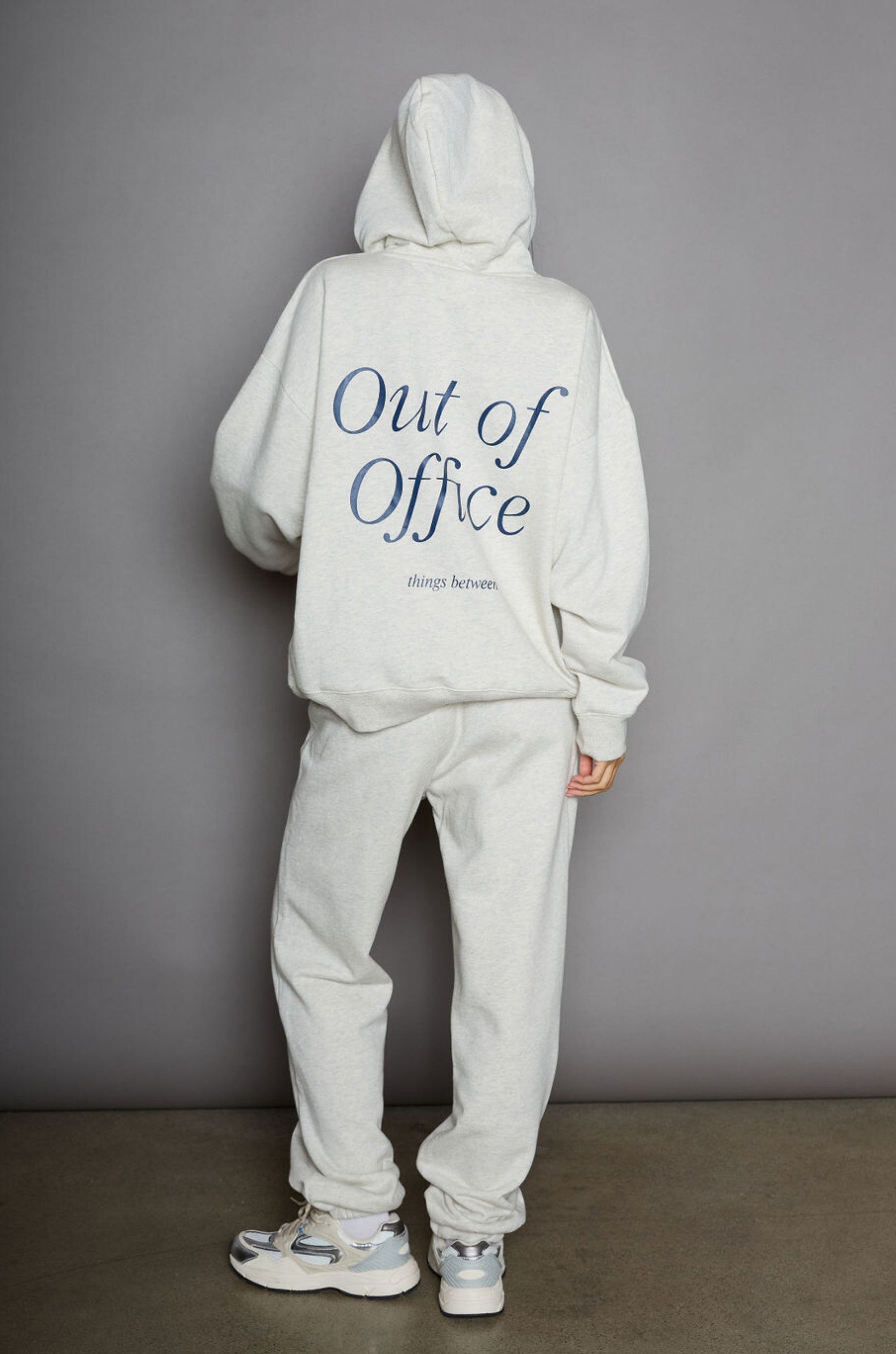 Graphic printed knit sweatset. Elastic waistband and leg openings. Side pockets. Fleece lining. hooded sweater. sweatpant. grey sweatset. out of office sweat set