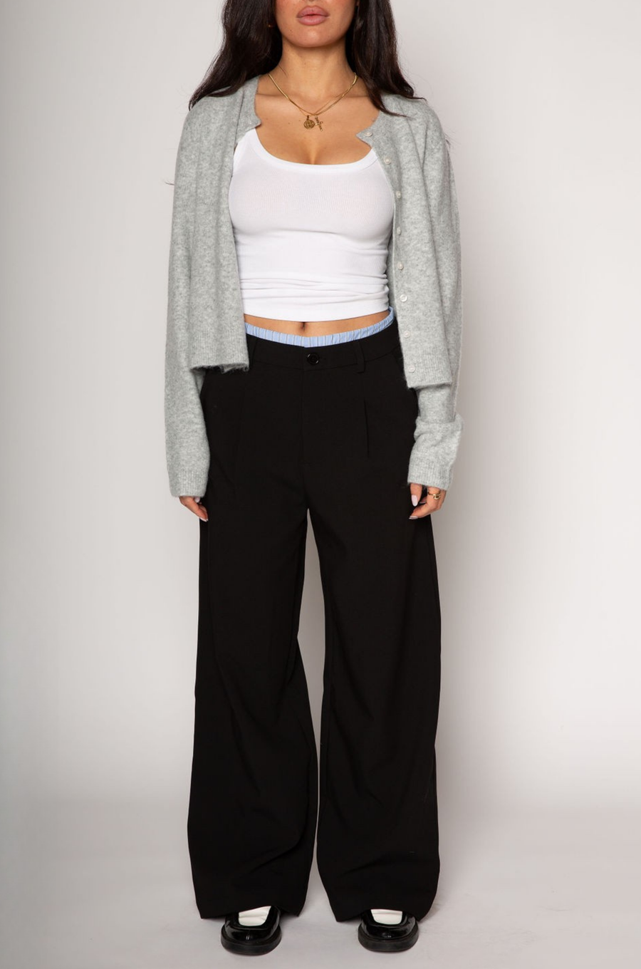 Black stretch trouser pants. Trimmed waist. Button and zipper fly. Side pockets. Faux back pockets. Unlined. layered slacks