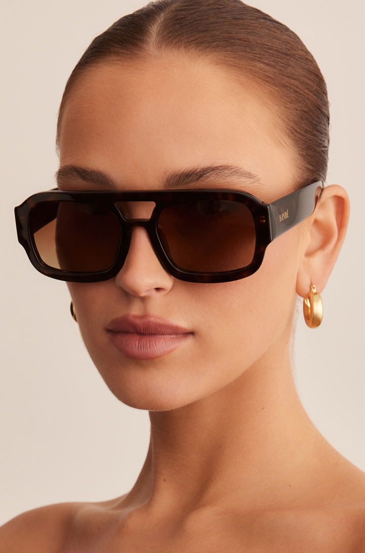 The Suki by Banbé are modern aviator sunglasses
Gold embossed Banbé logo on outer left arm
Style details printed in gold foil on inner right arm
Scratch resistant/category 3/polarized lens
100% UV protection
Acetate frame
Includes branded vegan case &amp; cleaning cloth
Designed in Australia
Width: 10.5cm / Lens Height: 5.1cm / Arm Length: 14cm / Nose Bridge: 3.5cm
pink lens sunglasses
tort and pink sunglasses