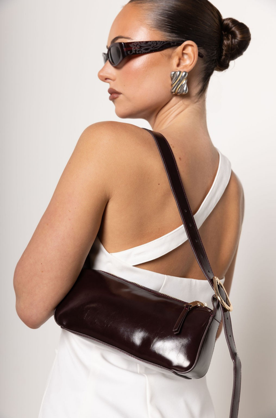 burgundy Shine rectangle shoulder bag
Top zip closure
Gold hardware detailing
Adjustable shoulder strap with buckle fastening
Inner zipper card slot