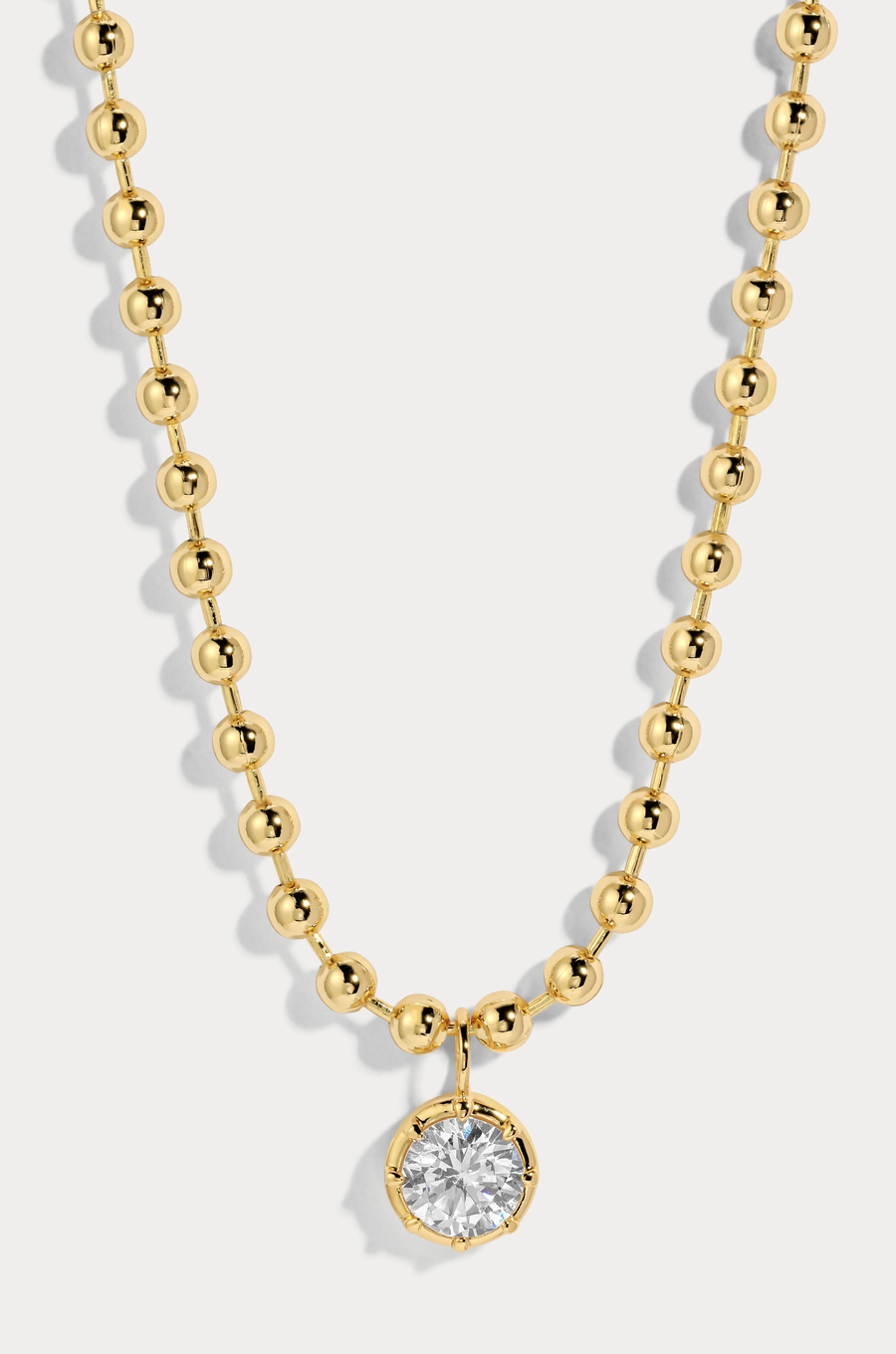 Delicate ball chain necklace anchored with a luminous CZ pendant
14kt gold plated brass&nbsp;or Rhodium plated brass
Stone is a white cz and measures 8.0mmNecklace measures 16" with a 3" extender
Lobster Clasp Closure
Gold chain necklace