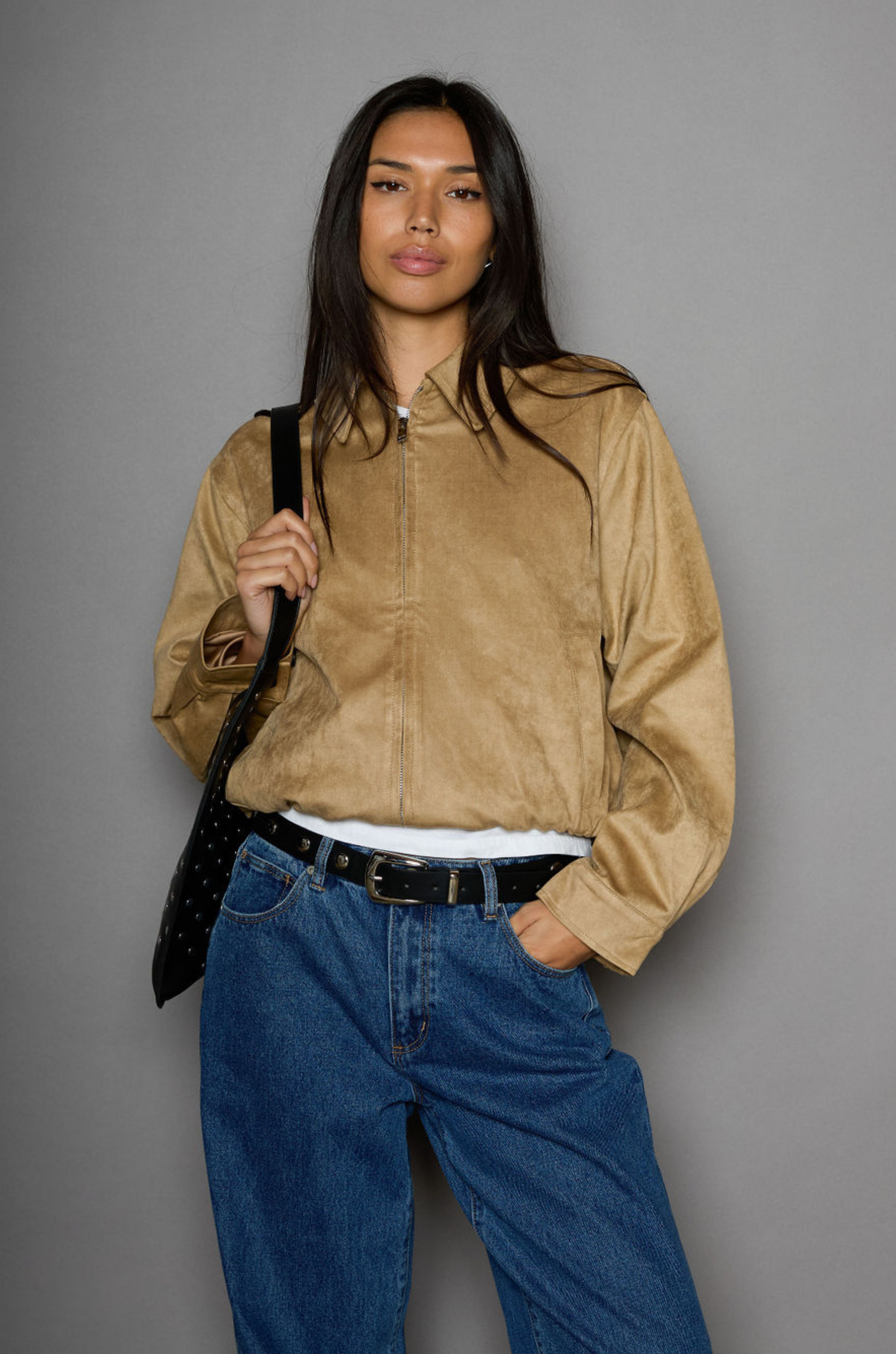 Vegan suede bomber jacket. Collar neckline. Front zipper closure. Elastic hems. Front pockets with snap button closures. Fully lined. tan suede bomber
