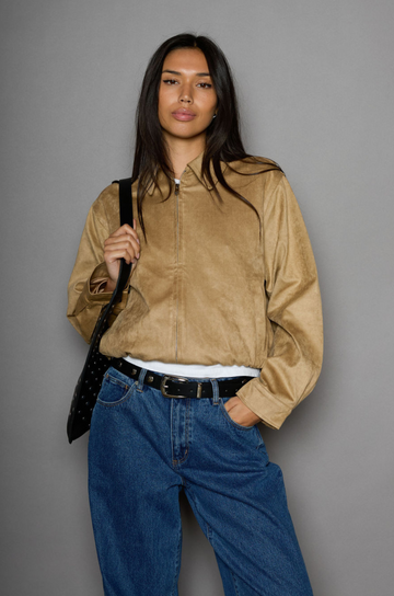 Vegan suede bomber jacket. Collar neckline. Front zipper closure. Elastic hems. Front pockets with snap button closures. Fully lined. tan suede bomber