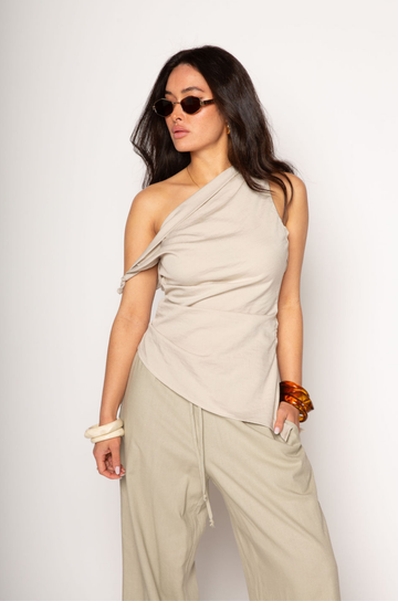 Woven top. Fixed straps. Twist strap. Ruched side. Asymmetric hem. Unlined. resort top. resort vacation top. resort outfit. asymmetrical top